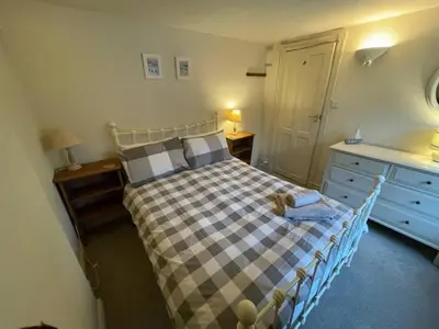 a bedroom with a bed with a checkered blanket at Praxis Trebarwith Strand in Treknow