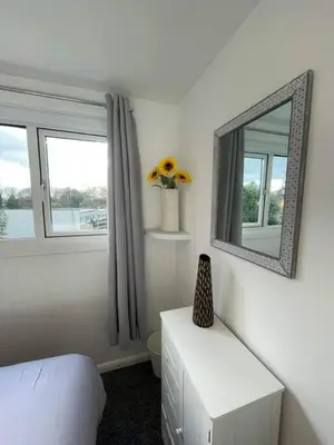 a bedroom with a mirror and a table and a bed at Villa 22 Lanteglos Hotel in Lanteglos