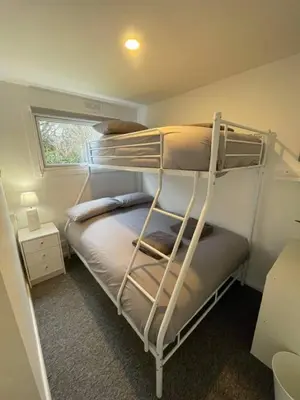 a bedroom with two bunk beds with a window at Villa 22 Lanteglos Hotel in Lanteglos