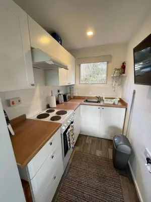 a small kitchen with white cabinets and a stove at Villa 22 Lanteglos Hotel in Lanteglos