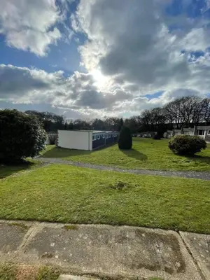 a field of grass with a building in the background at Villa 22 Lanteglos Hotel in Lanteglos