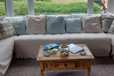 a living room with a couch with a coffee table at 1 Bed Caravan Sleeps 2 -Dog Welcome -Free Parking in Penzance