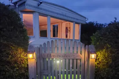 a white fence in front of a house at 1 Bed Caravan Sleeps 2 -Dog Welcome -Free Parking in Penzance