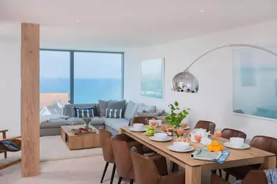a living room with a table and a couch at Beachfront Townhouse Lovely Sea Views Newquay in Newquay