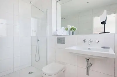 a white bathroom with a toilet and a sink at Beachfront Townhouse Lovely Sea Views Newquay in Newquay