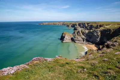 a view of a beach with rocks and the ocean at Beachfront Townhouse Lovely Sea Views Newquay in Newquay