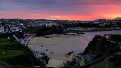 a view of a river at sunset with a city at Beachfront Townhouse Lovely Sea Views Newquay in Newquay