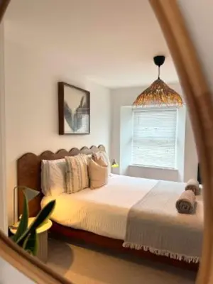a bedroom with a bed and a mirror at The Palms Cottage Exclusive Use 3 Bedroom Parking Central Newquay in Newquay