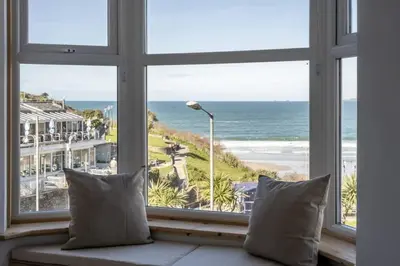a window with a view of the beach and the ocean at Spacious House Sea Views Opposite Beach in Newquay