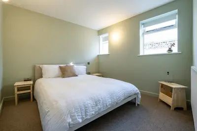 a bedroom with a white bed and a window at Spacious House Sea Views Opposite Beach in Newquay