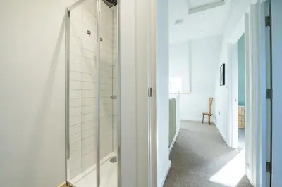 a bathroom with a shower with a glass door at Spacious House Sea Views Opposite Beach in Newquay
