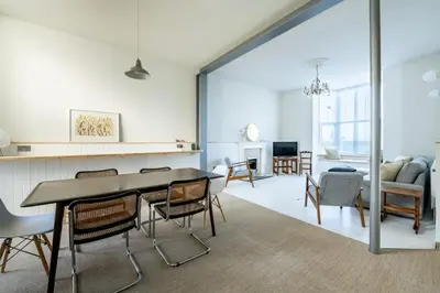 a dining room and living room with a table and chairs at Spacious House Sea Views Opposite Beach in Newquay