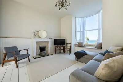a living room with a couch and a fireplace at Spacious House Sea Views Opposite Beach in Newquay