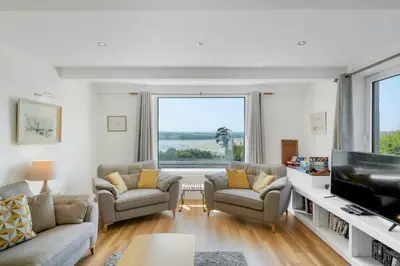 a living room with two couches and a tv at Beautiful Home with Pool Overlooking Camel Estuary in Roche