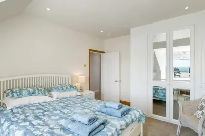 a bedroom with a bed with blue towels on it at Beautiful Home with Pool Overlooking Camel Estuary in Roche