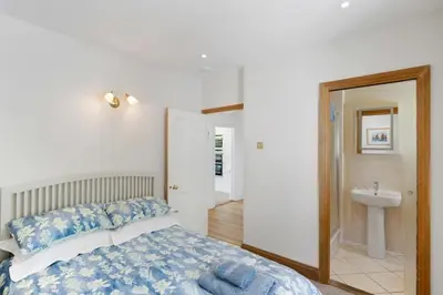 a bedroom with a bed and a bathroom with a sink at Beautiful Home with Pool Overlooking Camel Estuary in Roche