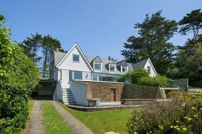 a large white house with a yard at Beautiful Home with Pool Overlooking Camel Estuary in Roche