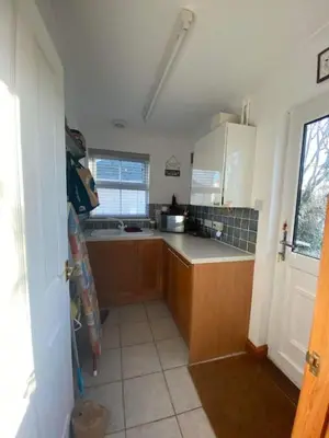 a kitchen with wooden cabinets and a counter top at The Meadows St Teath 4 bed sleeps 7 in Saint Teath