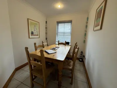 a dining room with a wooden table and chairs at The Meadows St Teath 4 bed sleeps 7 in Saint Teath