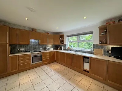 a large kitchen with wooden cabinets and a window at The Meadows St Teath 4 bed sleeps 7 in Saint Teath
