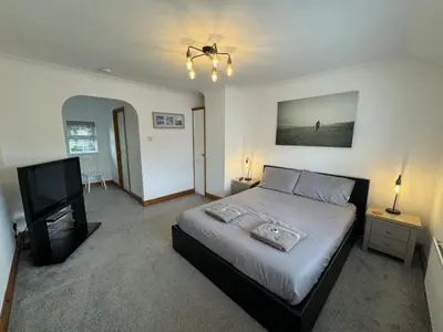 a bedroom with a bed and a flat screen tv at The Meadows St Teath 4 bed sleeps 7 in Saint Teath