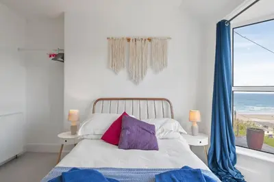 a bedroom with a bed with a view of the ocean at Beautiful Home with Sea Views & Parking in Porthtowan