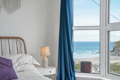 a bedroom with a bed and a view of the ocean at Beautiful Home with Sea Views & Parking in Porthtowan