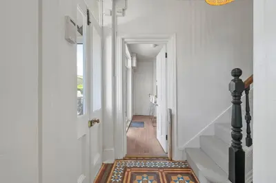 a hallway with stairs and a rug on the floor at Beautiful Home with Sea Views & Parking in Porthtowan