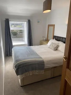 a bedroom with a bed with a mirror and a window at The Granary Couples & Families Retreat Near St Ives, Pet-Free in St Ives