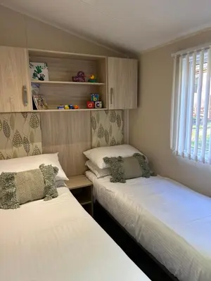 a bedroom with two beds and a window at Cabin in the Woods in Saint Erth