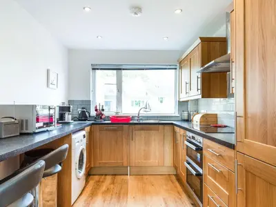 a kitchen with wooden cabinets and a sink at Orchard View in St Austell