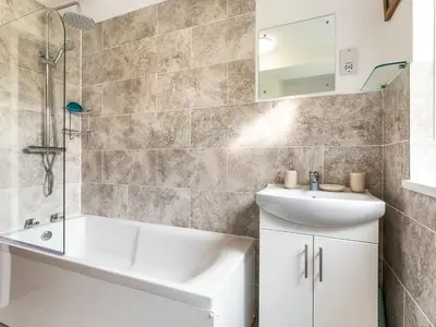 a bathroom with a tub and a sink and a shower at Orchard View in St Austell