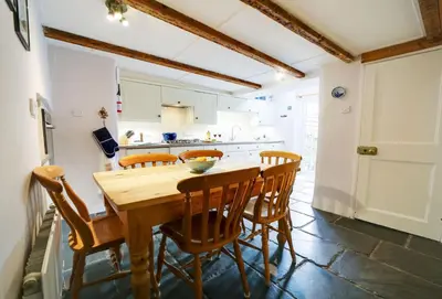 a kitchen with a wooden table and chairs at Hardys in Padstow