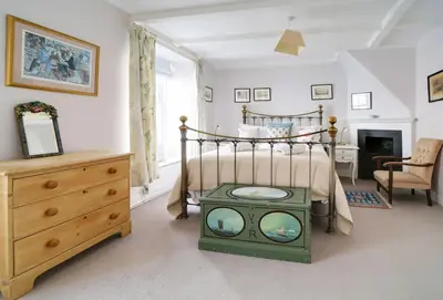 a bedroom with a bed with a tv in it at Hardys in Padstow
