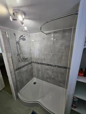 a shower with a glass door in a bathroom at Seahorse Cottage in Boscastle