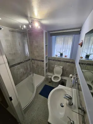 a bathroom with a shower toilet and a sink at Seahorse Cottage in Boscastle