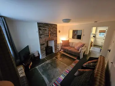 a living room with a couch and a fireplace at Seahorse Cottage in Boscastle