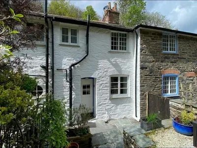 a white brick house with a white door at Seahorse Cottage in Boscastle