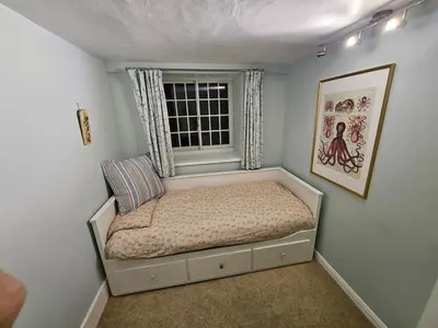 a bed in a room with a window at Seahorse Cottage in Boscastle