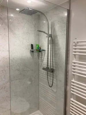a shower in a bathroom with a glass shower stall at The Eliot Cottage in South Petherwin