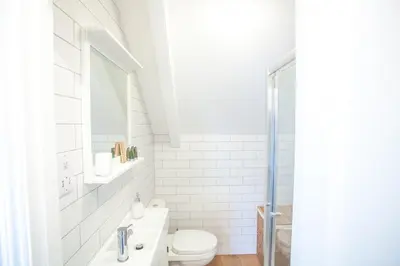 a white bathroom with a toilet and a sink at The Attic, Tre-Pol-Pen in St Ives