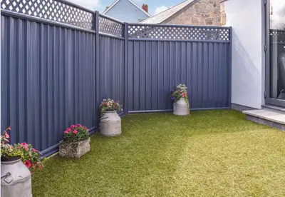 a backyard with three potted plants and a fence at Pentarow Barn in Falmouth