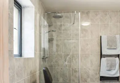 a bathroom with a shower with a glass door at Pentarow Barn in Falmouth