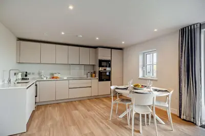 a kitchen with white cabinets and a table and chairs at 2 Bed in Padstow oc-28108 in Padstow