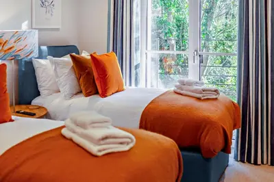 a bedroom with two beds with orange and white towels at 2 Bed in Padstow oc-28108 in Padstow