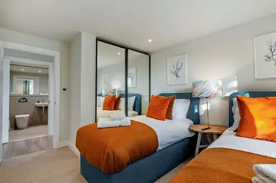a bedroom with two beds with orange pillows at 2 Bed in Padstow oc-28108 in Padstow