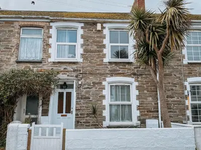 a brick house with a palm tree in front of it at Twiga Cottage - Quiet 2 bed - Heart of town - Walk to beaches in Newquay