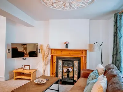 a living room with a couch and a fire place at Twiga Cottage - Quiet 2 bed - Heart of town - Walk to beaches in Newquay