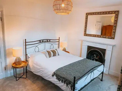 a bedroom with a bed with a fireplace and a mirror at Twiga Cottage - Quiet 2 bed - Heart of town - Walk to beaches in Newquay