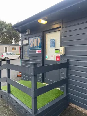 a stop gas station with a fence in front of it at 26 The Green Captains Cabin in Crantock